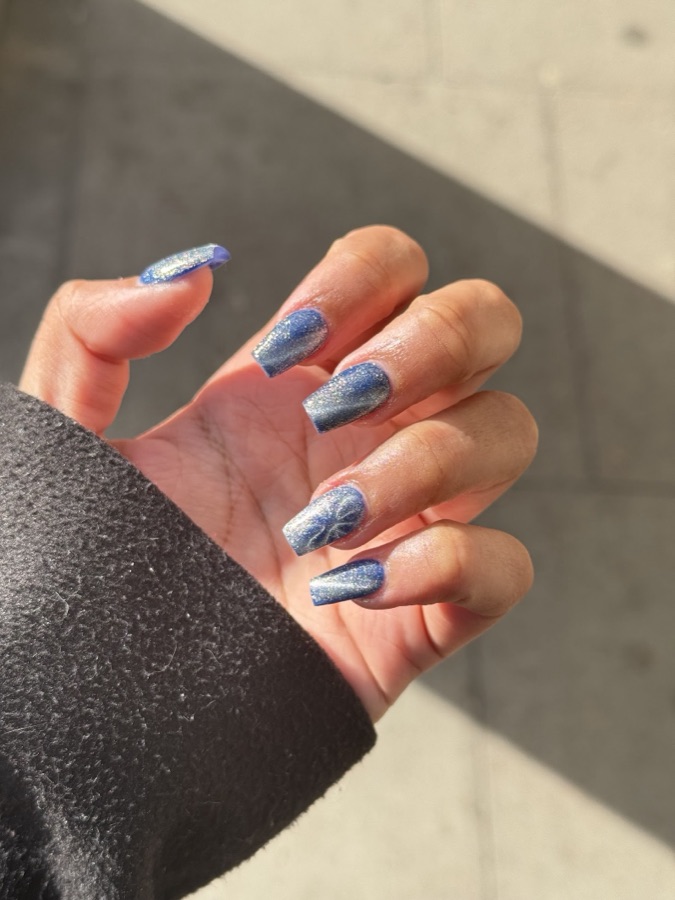 Close-up of finished sapphire cat-eye gel nails with silver flecks, styled at Jills Hair Salon